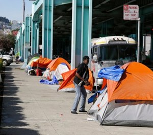 In this Feb. 23, 2016 file photo, a man stands outside of his tent on Division Street in San Francisco.