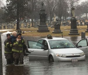 Firefighters saved two elderly women from knee-deep floodwaters after their car stalled in a deep puddle.
