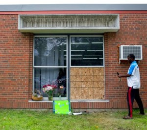 Abdul Mohamed photographs the damage outside of the Dar Al Farooq Islamic Center in Bloomington, Minn., on Sunday, Aug. 6, 2017. An explosion damaged a room and shattered windows as worshippers prepared for morning prayers early Saturday.