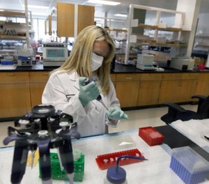 In this Feb. 17, 2012, file photo, Senior Criminalist Heide Elliott works on extracting DNA at the State of California Department of Justice Jan Bashinski DNA Laboratory in Richmond, Calif. (AP Photo/Jeff Chiu, File)