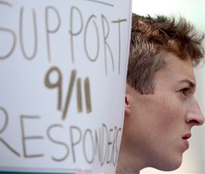 An activist holds a sign in support of 9/11 responders during a news conference, Thursday, Sept. 3.