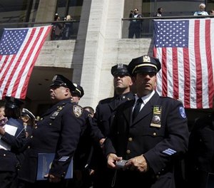 Police officers watch bag pipers play after leaving a ceremony to honor police officers killed during or as a result of the 9/11 terrorist attacks in New York, Thursday, Sept. 8, 2011.