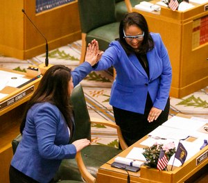 In this Jan. 9, 2017 file photo, Rep. Teresa Alonso Leon and Rep. Janelle Bynum, right, high-five after members of the House of Representatives are sworn into office at the Oregon State Capitol in Salem, Ore. (Molly J. Smith/Statesman-Journal via AP, File)