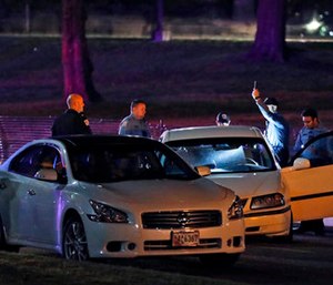 Investigators with Metropolitan Police Department examine a vehicle after a pursuit.