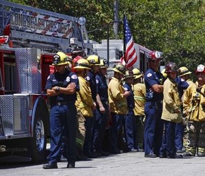 Long Beach firefighters gather at Saint Mary Medical Center as they transport the body of Fire Capt. Dave Rosa who was killed after he was shot responding to an emergency at a senior home.