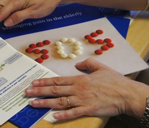 In this May 4, 2017 photo, Melissa Jones, a nurse educator with Alosa Health, explains educational materials on opioids and managing pain at a doctor's office in Elizabeth, Pa. Jones visits medical offices in western Pennsylvania to educate doctors about new opioid prescribing guidelines. (AP Photo/Carla K. Johnson)