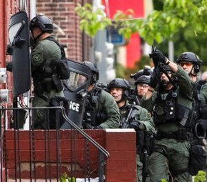 Police move in during standoff with a man in a home in Trenton, N.J., Wednesday, May 10, 2017. Police said they are trying to negotiate with a man holed up in a home after a fatal gunfire exchange with police. (AP Photo/Matt Rourke)