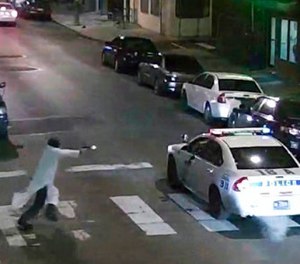 In this Jan. 7, 2016, image made from a video provided by the Philadelphia Police Department, a gunman runs toward a police car driven by Philadelphia police officer Jesse Hartnett in Philadelphia.