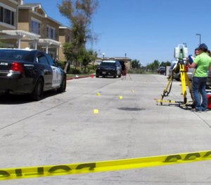 Investigators check a crime scene where two police officers and a burglar were shot on Monday, July 31, 2017, at an apartment complex in Los Banos, Calif. (AP Photo/Scott Smith)
