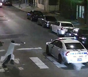In this frame from a Thursday, Jan. 7, 2016 video provided by the Philadelphia Police Department, Edward Archer runs with a gun toward a police car driven by Officer Jesse Hartnett in Philadelphia.
