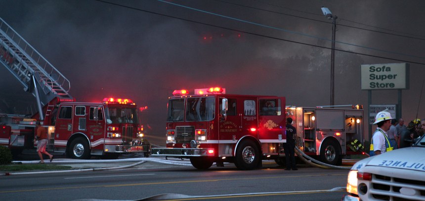 Smoke fills the air and fire trucks respond as a fire sweeps through the Sofa Super Store furniture warehouse in Charleston,S.C. on June 18, 2007. Nine firefighters died in the blaze when a roof collapsed making it the nation’s single deadliestdisaster for firefighters since 9/11.