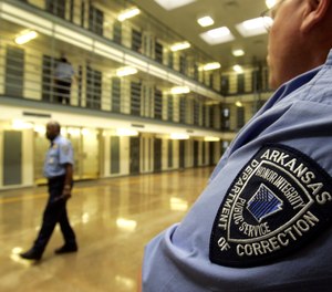 In this file photo taken Aug. 10, 2009, guards patrol a cell block at the Cummins Unit of the Arkansas Department of Correction near Varner, Ark.