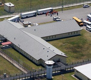 Inmates exit buses at Elayn Hunt Correctional Center in St. Gabriel, La., Monday, May 9, 2011.