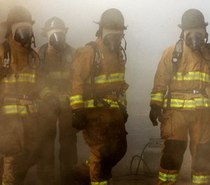 Oklahoma City Fire Department recruits exit a flashover simulator during training in Choctaw, Okla., Monday, Jan. 30, 2012.