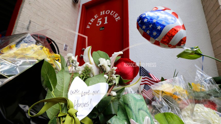 A handwritten note attached to flowers placed at a makeshift memorial outside Houston Fire Station 51 pays tribute to the firefighters who perished Saturday, June 1, 2013, in Houston.