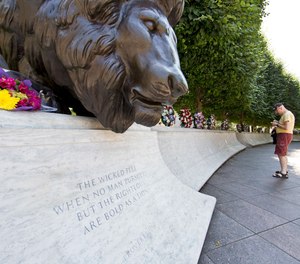 A man looks at the engraved names of fallen law enforcement officers at The National Law Enforcement Officers Memorial in Washington, Friday, July 8, 2016.
