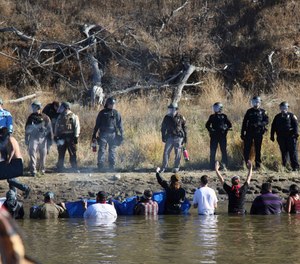 In this Nov. 2, 2016 file photo, protesters demonstrating against the expansion of the Dakota Access pipeline wade in cold creek waters confront local police near Cannon Ball, N.D.