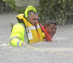 Wilford Martinez, right, is rescued from his flooded car by Harris County Sheriff's Department Richard Wagner. (Photo/AP)