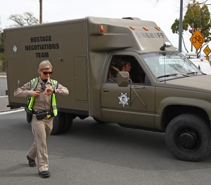 A sheriff's hostage negotiation team passes a California highway patrol checkpoint at the Veterans Home of California in Yountville, Calif., Friday, March 9, 2018. Napa County Fire Capt. Chase Beckman says a gunman has taken hostages at the veterans home. Police closed access to the large veterans home after a man with a gun was reported on the grounds.