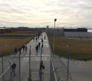 Inmates walk across the grounds of the Idaho State Correctional Institution in Kuna, Idaho.