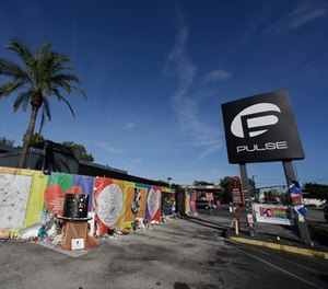 In this Nov. 30, 2016 file photo, artwork and signatures cover a fence around the Pulse nightclub, scene of a mass shooting, in Orlando, Fla. (AP Photo/John Raoux)