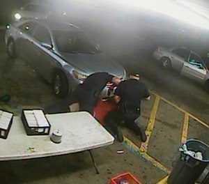 In this still image taken from security camera video provided Friday, March 30, 2018, by the Baton Rouge Police Department, officers Blane Salamoni and Howie Lake II confront Alton Sterling during a struggle outside the Triple S Food Mart in Baton Rouge, La., in July 2016.