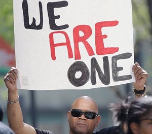 An attendee holds a sign as he joined others at a rally aimed at ensuring the memory of police shooting victim Stephon Clark and calling for police reform, Saturday, March 31, 2018, in Sacramento, Calif.