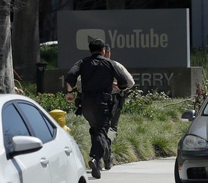 Officers run toward a YouTube office in San Bruno, Calif., Tuesday, April 3, 2018. Police and federal officials have responded to reports of a shooting Tuesday at YouTube headquarters in Northern California.