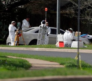 In this March 19, 2018, file photo, federal investigators work near the site of an explosion in Austin, Texas.