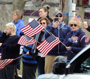 Well wishers line up outside the Doane Beal and Ames Funeral home on West Main Street in Hyannis, Mass., Tuesday, April 17, 2018, where the body of Yarmouth Police Officer Sean Gannon was transported by motorcade to South Yarmouth.