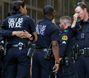 Dallas Police officers wait outside the entrance of the emergency room at Presbyterian Hospital, Tuesday, April 24, 2018, in Dallas, following a shooting at an area Home Depot where two police officers and a civilian were shot.