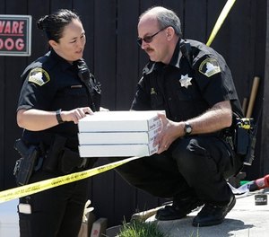 T. Abbott, left, and John Lopes, right, from the Sacramento County Sheriff's crime scene investigation office, conference about boxes of evidence gathered from the home of murder suspect Joseph DeAngelo, Thursday, April 26, 2018, in Citrus Heights, Calif.