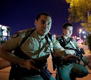 In this Oct. 1, 2017, file photo, police officers advise people to take cover near the scene of the Route 91 Harvest Music Festival mass shooting.