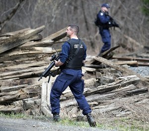 Maine state police search along railroad tracks near Mill Stream Road in Norridgewock, Maine, Friday, April 27, 2018, during a manhunt for John Williams, wanted in the shooting death of Somerset County Sheriff's Deputy Eugene Cole on Wednesday.