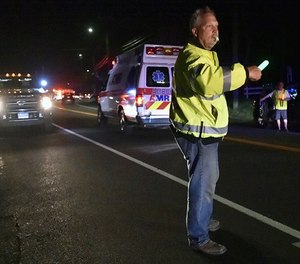 Emergency personnel stand on Quinnipiac Avenue in North Haven, Conn. near the scene of explosion and reported stand-off Wednesday, May 2, 2018. A house in Connecticut has exploded while police and a SWAT team were outside, responding to a report of a barricaded person. (Catherine Avalone/New Haven Register via AP)