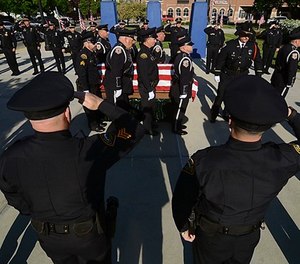 Officers with the Terre Haute Police Department and members of other agencies form a cordon to pay respect to fallen Terre Haute Police Officer Rob Pitts as his casket is carried on Tuesday, May 8, 2018, outside of Hulman Center in Terre Haute, Ind.