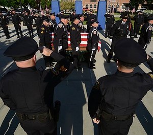 Officers with the Terre Haute Police Department and members of other agencies form a cordon to pay respect to fallen Terre Haute Police Officer Rob Pitts as his casket is carried on Tuesday, May 8, 2018, outside of Hulman Center in Terre Haute, Ind.