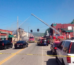 Emergency vehicles block a street in downtown Talihina, Okla., Friday, May 11, 2018, after a large fire began when search warrants were being served in the small Oklahoma town.