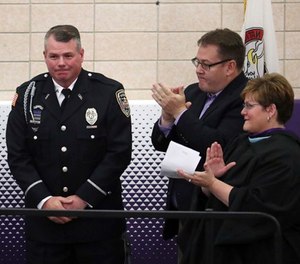 Officer Mark Dallas is honored during graduation ceremonies Sunday, May 20, 2018 at Dixon High School.