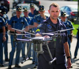 In this Sept. 28, 2017, file photo, Maine State Police Sgt. Darren Foster discusses the collision avoidance system on an unmanned aerial vehicle used for traffic accident investigations, while speaking outside Maine State Police headquarters at the Central Maine Commerce Center in Augusta, Maine.