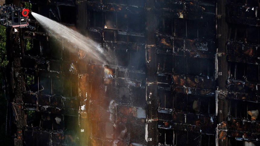 In this Wednesday, June 14, 2017 file photo, the sun creates a rainbow effect as firefighters work at the scene of a deadly blaze at a high rise apartment block in London.