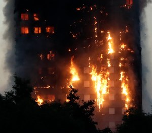 In this Wednesday, June 14, 2017 file photo, smoke and flames rise from the Grenfell Tower building on fire in London.