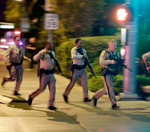 In this Oct. 1, 2017, file photo, police run toward the scene of a shooting near the Mandalay Bay resort and casino on the Las Vegas Strip in Las Vegas.