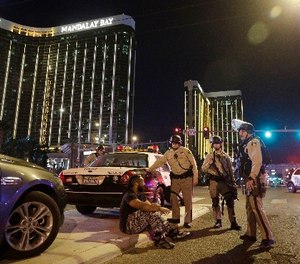 In this Oct. 1, 2017 file photo, police officers stand at the scene of a mass shooting near the Mandalay Bay resort and casino on the Las Vegas Strip, in Las Vegas. (AP Photo/John Locher, File)