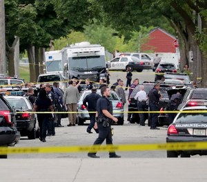 Authorities investigate the scene where a Milwaukee Police officer was fatally shot near North 28th and West Wright streets, Wednesday, July 25, 2018, in Milwaukee. A suspect is in custody.