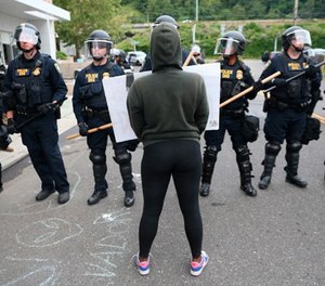 In this June 28, 2018, file photo, Department of Homeland Security officers take action to reopen Portland's Immigration and Customs Enforcement headquarters in Portland, Ore.