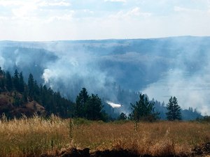 In this photo released by the Eastern Area Incident Management Team, a Fire Boss plane, a fixed-wing aircraft used in wildland fire suppression, battles a wildfire in eastern Washington state on Aug. 5, 2018.