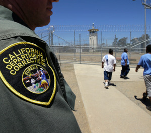 Inmates pass a correctional officer as they leave an exercise yard at the California Medical Facility in Vacaville, Calif.