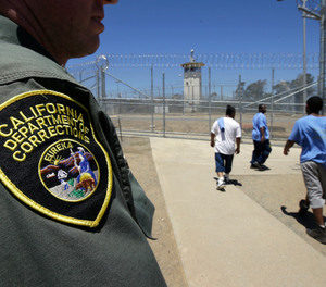 Inmates pass a correctional officer as they leave an exercise yard at the California Medical Facility in Vacaville, Calif.
