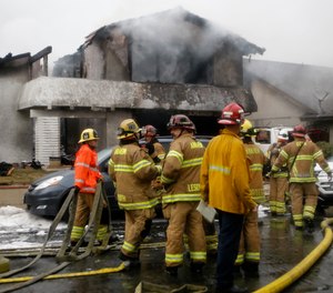 Firefighters suppress a fire at the scene of a deadly plane crash in the residential neighborhood of Yorba Linda, Calif., Sunday, Feb. 3, 2019. The Federal Aviation Administration said a twin-engine Cessna 414A crashed in Yorba Linda shortly after taking off from the Fullerton Municipal Airport. (AP Photo/Alex Gallardo)